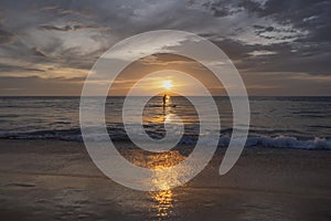 Sunset on the sea with silhouette of man with a Paddle on a SUP board