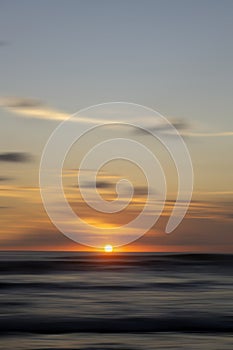 Sunset in the sea. The sun dawn over horizon in the beach. Golden sunset view background with smooth wave motion . photo