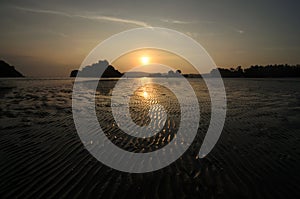 Sunset at the seaside in a low tide when bottom of the sea is visible