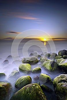 Sunset seen from rocky coast