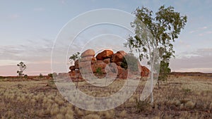 sunset shot of the devil's marbles boulders and a gum tree