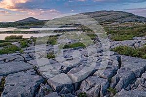 A sunset shot of the stunning and mars like landscape that is The Burren National Park, County Clare, Ireland with small lake in