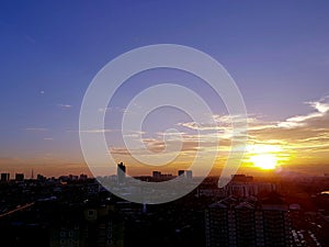 Sunset with silhouette of buildings over Johor Bahru`s cityscape