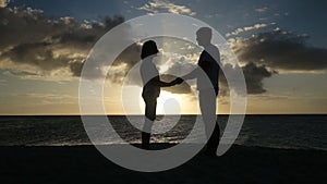 Sunset silhouette of couple on the beach