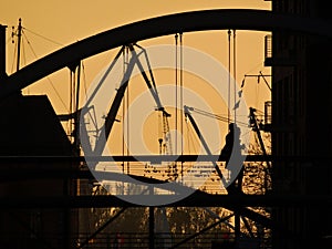Sunset silhouette of Couple on Hamburg bridge with lovelocks and industrial theme