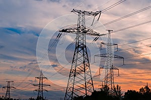 Sunset with a silhouette of electricity pylon and power lines