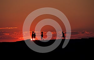 Sunset Silhouette of Group of Kids Talking