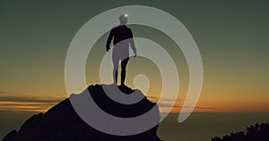 Sunset, silhouette and man mountain climbing while hiking in nature, fitness and light in dark for travel. Exercise