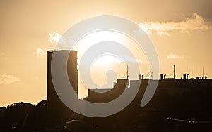Sunset silhouette of an oil tank and other indusrial buildings