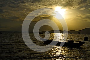 Sunset silhouette with small boat on beach