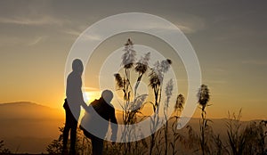 Sunset silhouette two Young look to Sunset