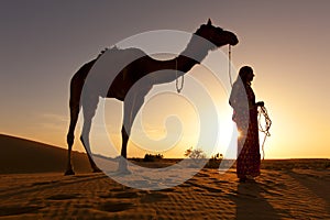 Sunset Silhouette of a woman and her camel.