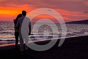 Sunset silhouette of young couple in love hugging at beach