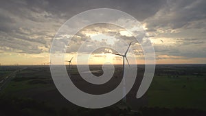 Sunset Silhouettes of Wind Turbines on Rural Landscape