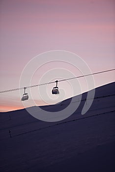 Sunset in skiing resort. Beautiful pink sky. Winter holiday in the mountains.