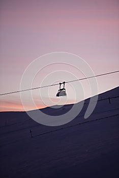 Sunset in skiing resort. Beautiful pink sky. Winter holiday in the mountains.