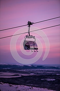 Sunset in skiing resort. Beautiful pink sky. Winter holiday in the mountains.