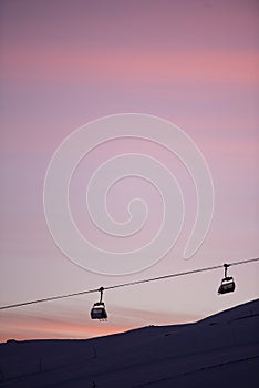 Sunset in skiing resort. Beautiful pink sky. Winter holiday in the mountains.