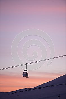 Sunset in skiing resort. Beautiful pink sky. Winter holiday in the mountains.