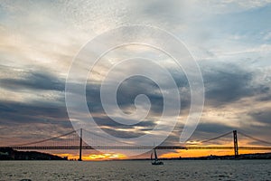 Sunset sky above Tagus River, Bridge April 25 Lisbon and port at from ship, Portugal.