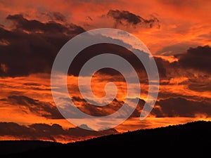 Focoso il cielo nuvole nuvola arancia fiamma esplosione nero tempesta bruciando tramonto montagne alba 