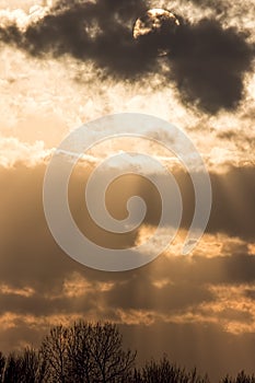 Sunset sky background, Sun behind dark cloud with crepuscular ra