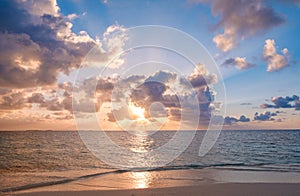 Sunset sky with colorful clouds over ocean and beach