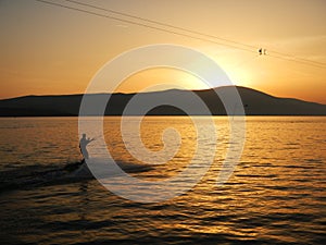 Sunset sky, mountain, sea and water skiing