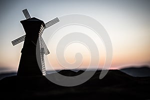 Sunset sky and old windmill standing on hill