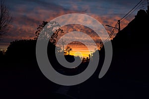 Sunset sky over a dark street of a rural town in winter