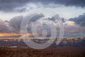 Sunset sky with storm clouds over the city and forest