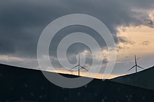 Sunset sky view and wind turbines top of hill