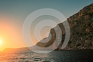 Sunset and Steep Cliffy Rocky Sea Shore. Sea and Rocks