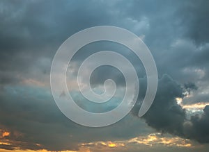 Sunset in stormy dark grey clouds