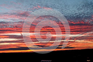 Sunset in the summer in the East of England. A layered gold, red and white sunset overlooking a nature reserve.