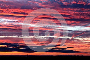 Sunset in the summer in the East of England. A layered gold, red and white sunset overlooking a nature reserve.