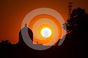 Sunset in summer with silhouette of church dome, Italy