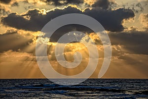 Sunset with sun beams over the sea