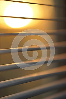 Sunset sun behind horizontal blinds, macro shot