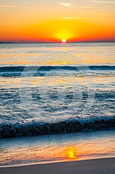 The sunset sun is going down behind the horizon. Tyrrhenian Sea bay with Elba island on the background at the sunset. Cala Violina