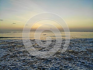 Aerial view of sunset over the sea with some small boats, Bali, Indonesia.