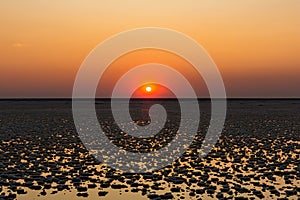 Sunset or sunrise on salt lake Elton (Russia) with mirror