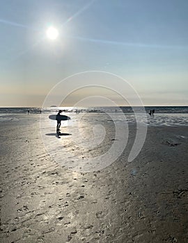 Sunset surfer heads home as evening approaches