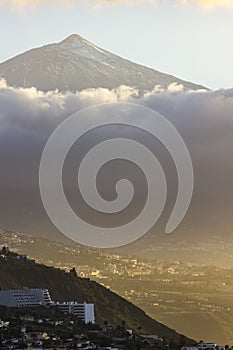 Sunset on tenerife island with view on villages on slope and teide volcano