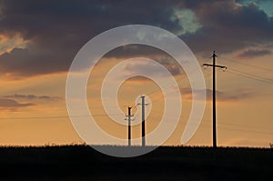 Sunset and three electric pylons