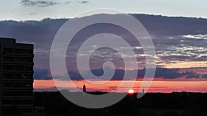 Sunset timelapse with lots of clouds and clouds in the sky in Munich, Germany. Silhouettes of houses, a church and a