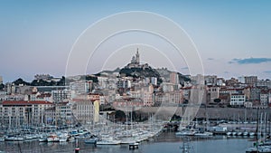 Sunset Timelapse of The Old Port and Basilica of Notre Dame de la Garde at dusk in Marseille, France