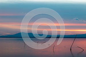 Sunset a Trasimeno lake Umbria, Italy, with poles on the foreground