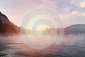 Sunset on Traunsee lake with alps mountain and misty fog. Summer Austria landscape