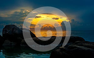 Sunset on tropical beach with with huge stones